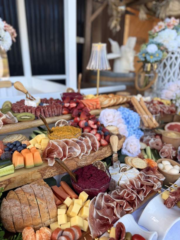 Close-up of prosciutto, cheeses, rockmelon and hydrangeas