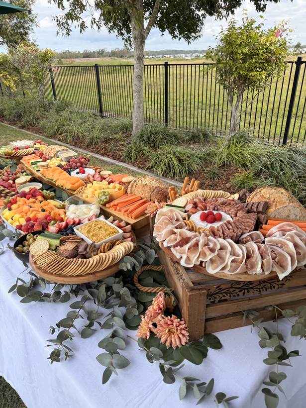 Outdoor grazing table on a lawn with eucalyptus