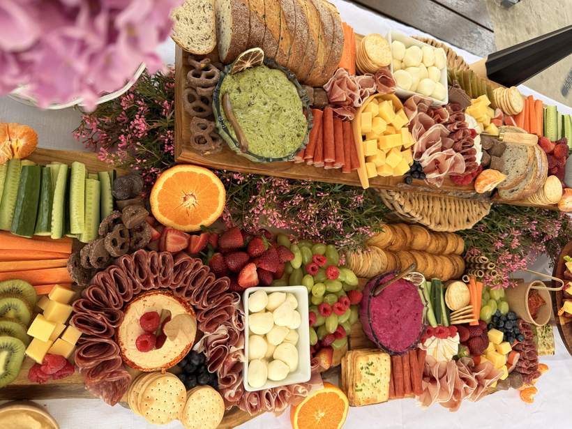 Long grazing table from above with pink waxflower and oranges